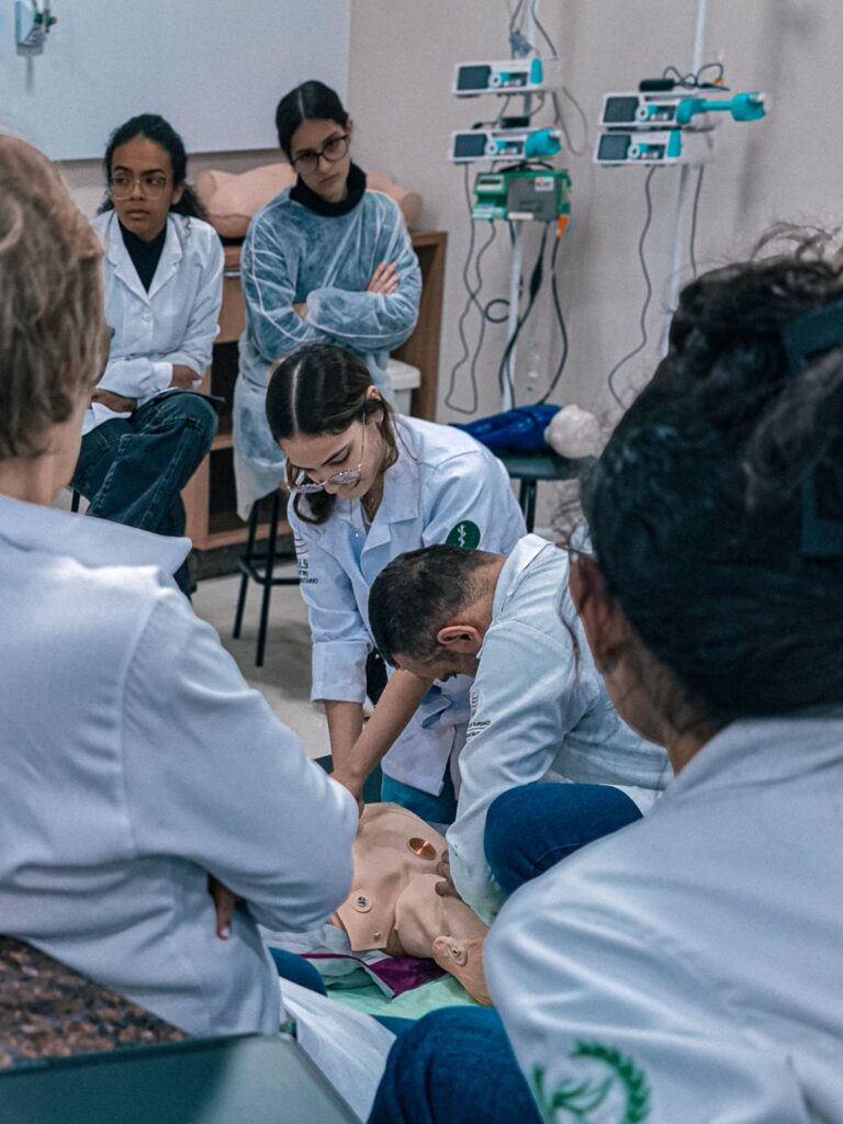 Group of medical students practicing on a dummy in a classroom setting in Brazil.
