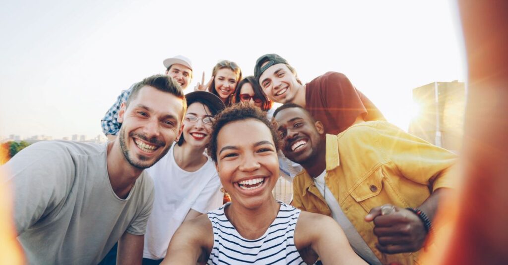 pexels photo 36729918 36729918 A diverse group of friends taking a joyful selfie outdoors during sunset.