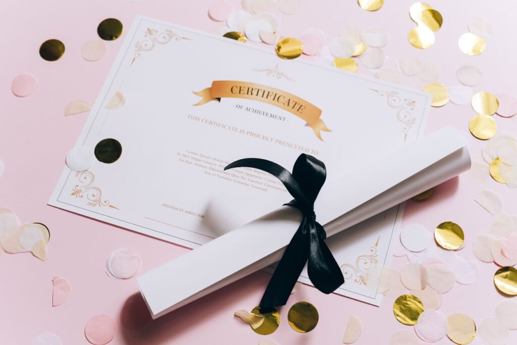 Elegant certificate of achievement on a pink surface with confetti. Perfect for celebrations and achievements.